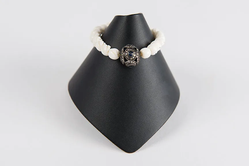 Carved bone with sapphire and diamond bead